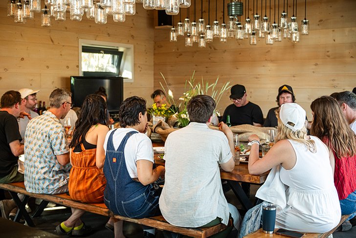 A group of people sitting at a large dining table sharing a meal